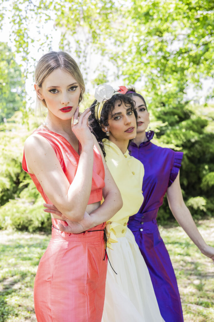 tre modeli con vestiti rosa, giallo e viola